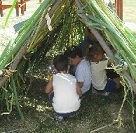 Gyékénykunyhót építő gyerekek